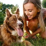 close up of young female with her dog sitting on grass in park 1